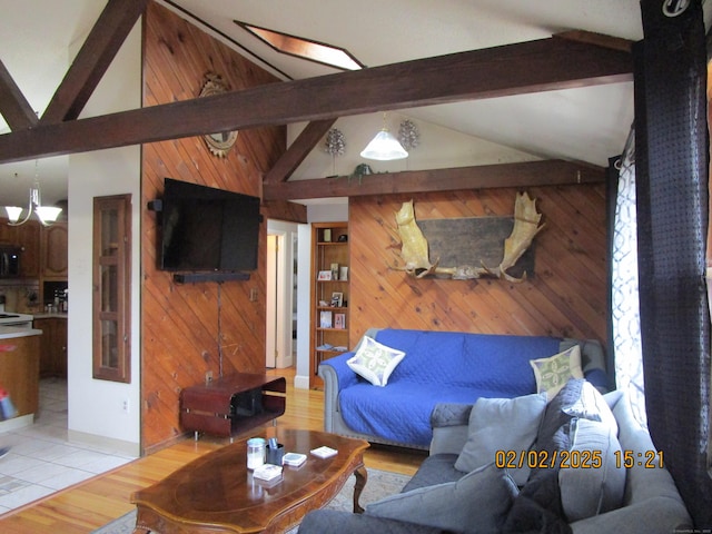 living area with beamed ceiling, light wood-style flooring, wood walls, and high vaulted ceiling