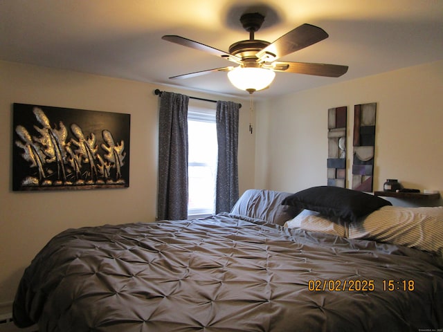 bedroom featuring a baseboard heating unit and a ceiling fan