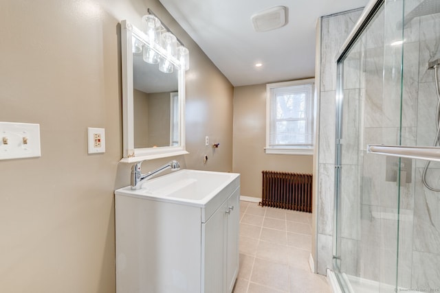 bathroom with tile patterned floors, a shower stall, radiator, and vanity