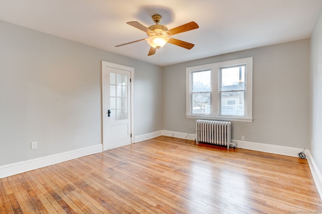 spare room with radiator, baseboards, and hardwood / wood-style floors