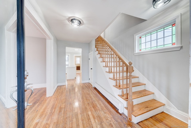 entrance foyer with a wealth of natural light, baseboard heating, and light wood-type flooring