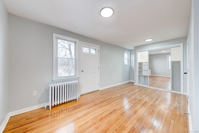 interior space featuring light wood-style flooring, radiator, and baseboards