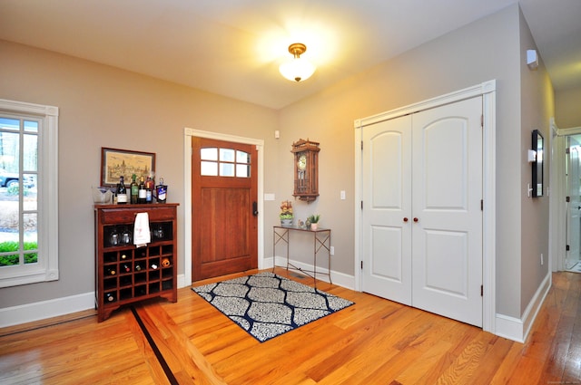 entryway featuring plenty of natural light, light wood-style flooring, and baseboards