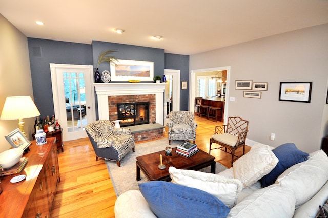 living room with recessed lighting, light wood-style flooring, a fireplace, and baseboards