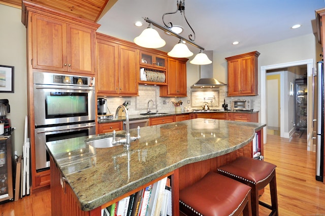 kitchen featuring a sink, brown cabinetry, tasteful backsplash, and stainless steel appliances