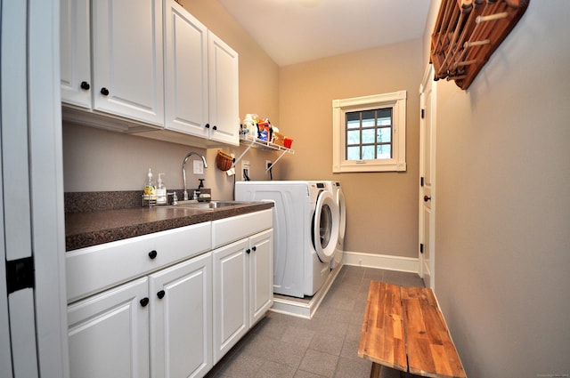 laundry area featuring cabinet space, washer and dryer, baseboards, and a sink