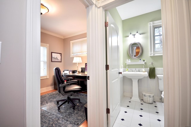 home office featuring tile patterned flooring, crown molding, baseboards, and a sink