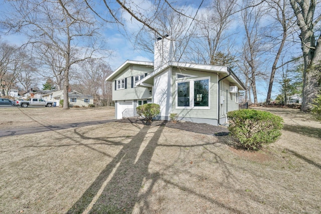 view of front of home featuring driveway and a chimney