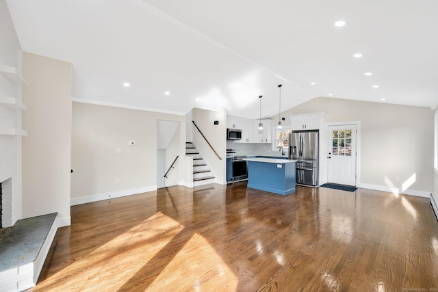 unfurnished living room featuring wood finished floors, stairway, baseboards, a fireplace, and lofted ceiling