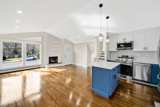 kitchen featuring blue cabinetry, open floor plan, lofted ceiling, a fireplace, and stainless steel appliances