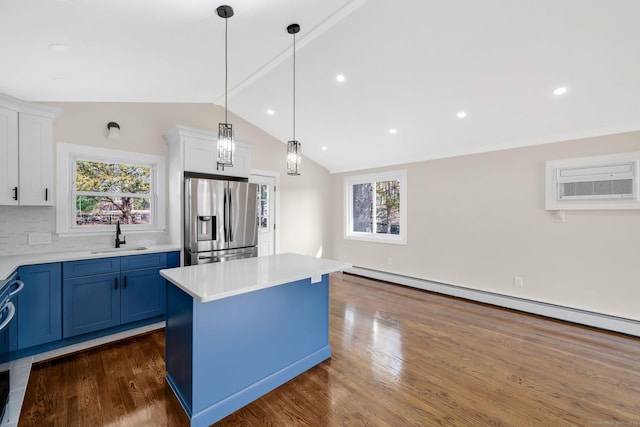 kitchen with blue cabinets, a wealth of natural light, stainless steel refrigerator with ice dispenser, a sink, and a wall unit AC