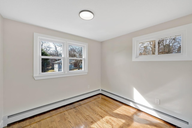 empty room with light wood-type flooring, baseboard heating, and a baseboard radiator