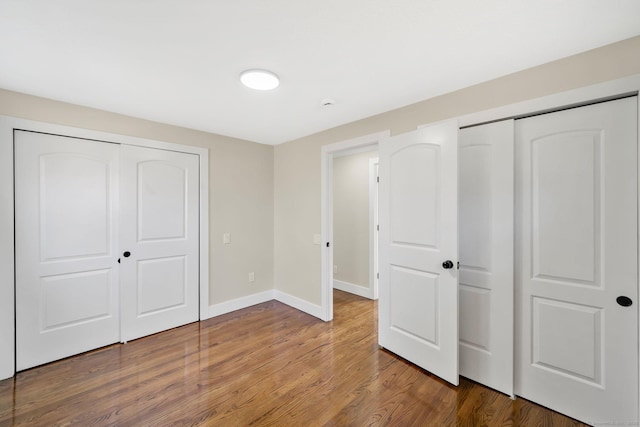 unfurnished bedroom with baseboards and wood finished floors