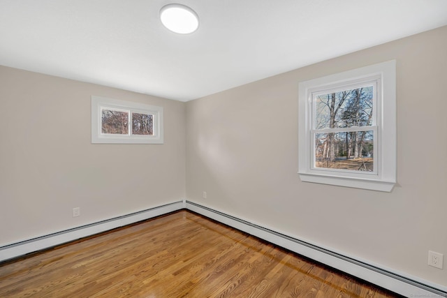 unfurnished room featuring wood finished floors and a baseboard radiator