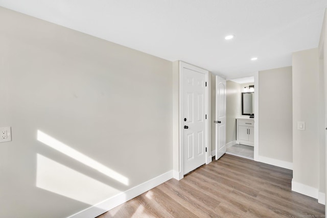 corridor with recessed lighting, baseboards, and light wood-style floors