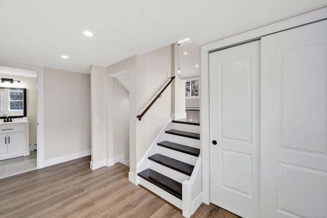 staircase with recessed lighting, baseboards, baseboard heating, and wood finished floors