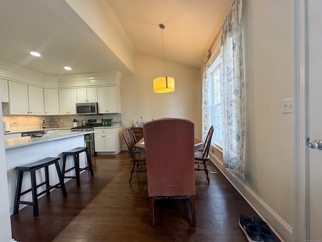 dining space with dark wood-style floors, recessed lighting, vaulted ceiling, and baseboards