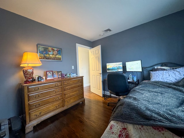 bedroom with visible vents, baseboards, and wood finished floors