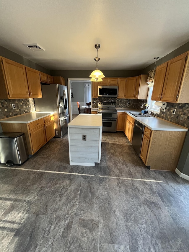 kitchen with a sink, backsplash, a center island, appliances with stainless steel finishes, and light countertops