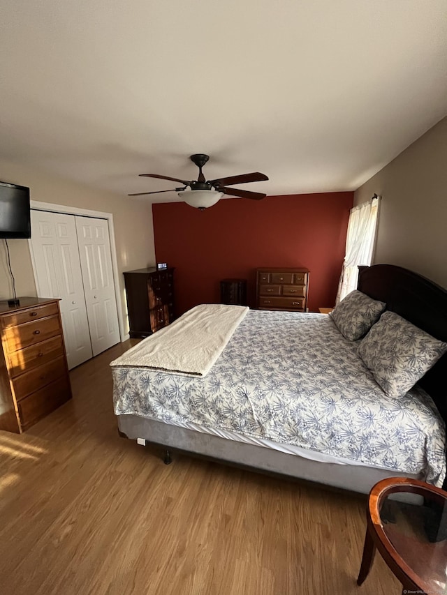 bedroom featuring a ceiling fan, wood finished floors, and a closet