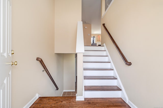 stairway featuring baseboards and wood finished floors