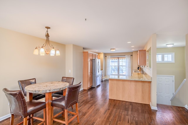 dining space with dark wood finished floors, an inviting chandelier, recessed lighting, and baseboards