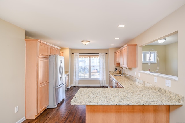 kitchen featuring a sink, a healthy amount of sunlight, light brown cabinetry, and freestanding refrigerator