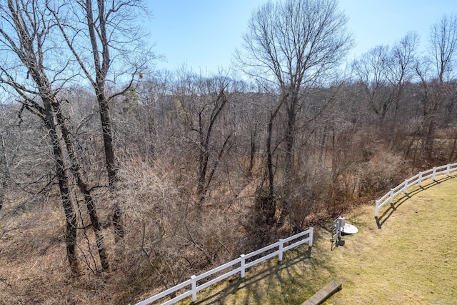 view of yard featuring fence and a forest view