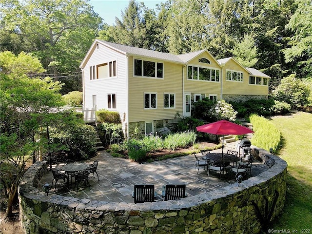 rear view of property featuring outdoor dining space and a patio