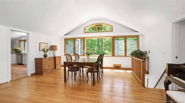 dining space featuring lofted ceiling, light wood-style floors, visible vents, and baseboards