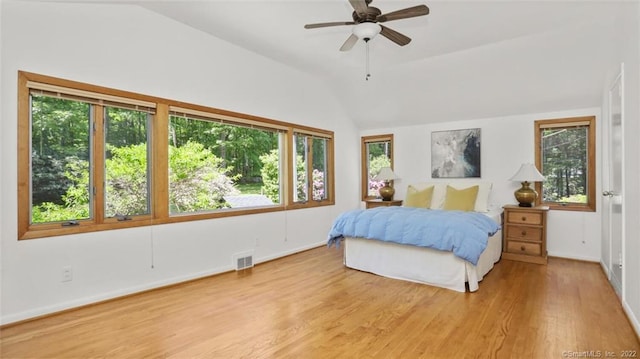 bedroom featuring vaulted ceiling, visible vents, multiple windows, and wood finished floors