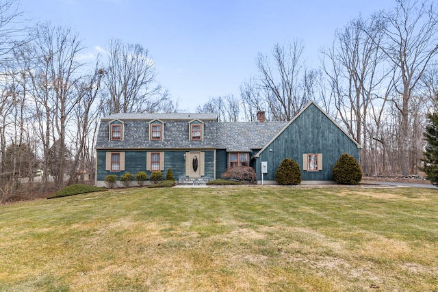 view of front of property with roof with shingles, a chimney, and a front lawn