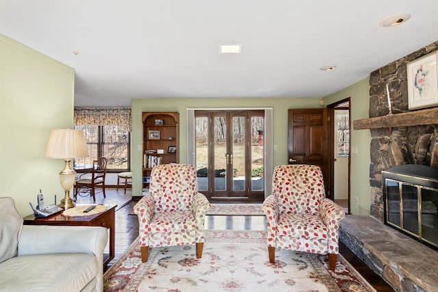 living area with a fireplace, a healthy amount of sunlight, and french doors