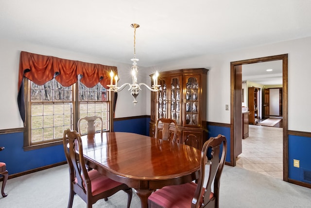 dining area featuring light tile patterned floors, visible vents, baseboards, a notable chandelier, and light colored carpet