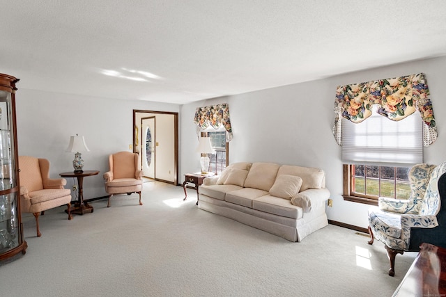 living room with baseboards, a textured ceiling, and carpet flooring