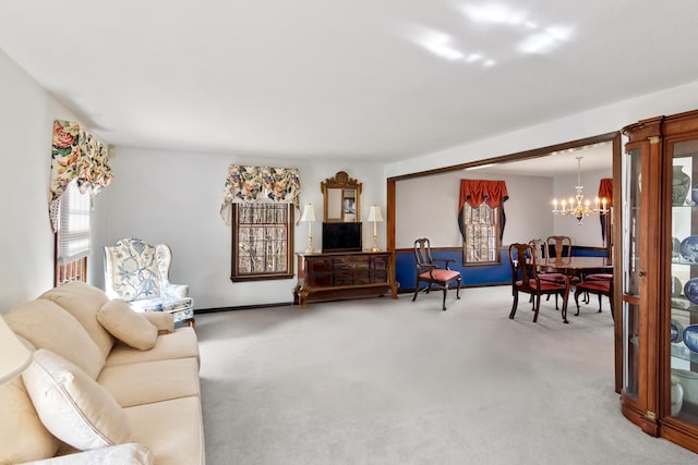 carpeted living room with a notable chandelier