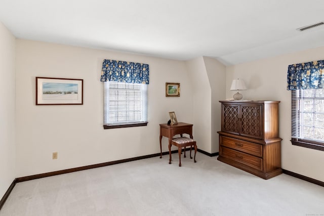 sitting room with light carpet, visible vents, baseboards, and vaulted ceiling