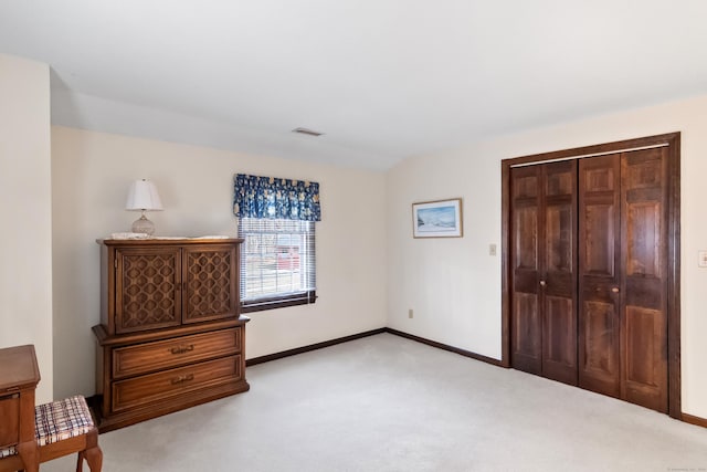 bedroom with visible vents, baseboards, light colored carpet, and a closet