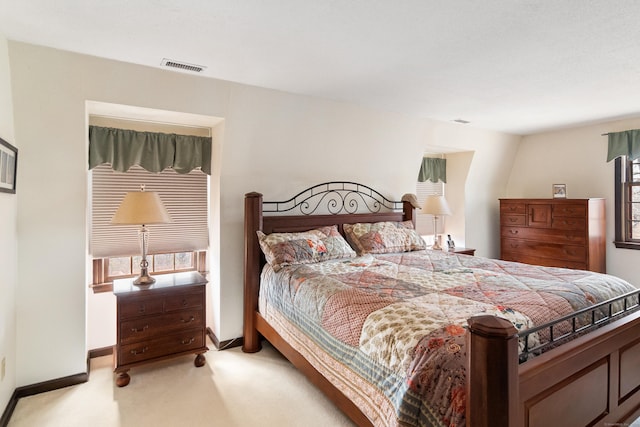 bedroom with visible vents, light carpet, and baseboards