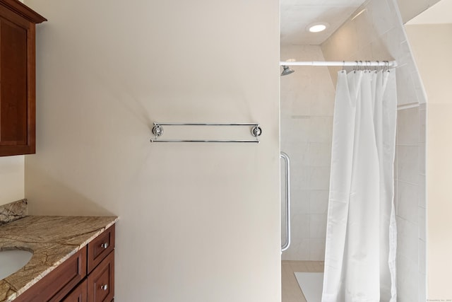 full bath featuring tiled shower and vanity