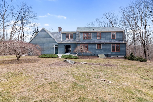 rear view of property with a lawn, cooling unit, a chimney, and roof with shingles