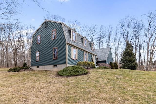 view of home's exterior with a gambrel roof and a yard