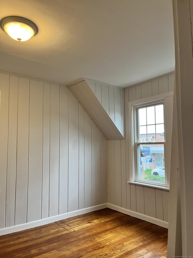 additional living space featuring wood finished floors and baseboards