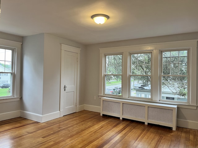 interior space with baseboards, radiator, and light wood-style flooring