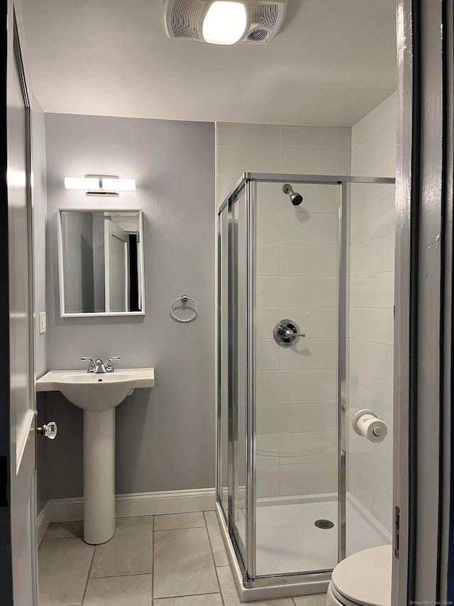 full bath featuring a shower stall, toilet, and baseboards