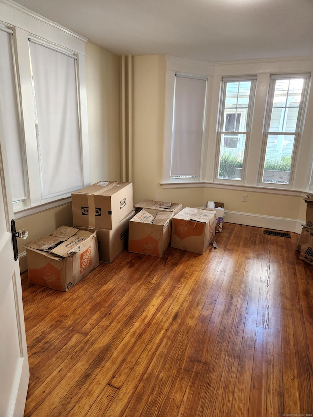 interior space featuring visible vents, baseboards, and hardwood / wood-style floors