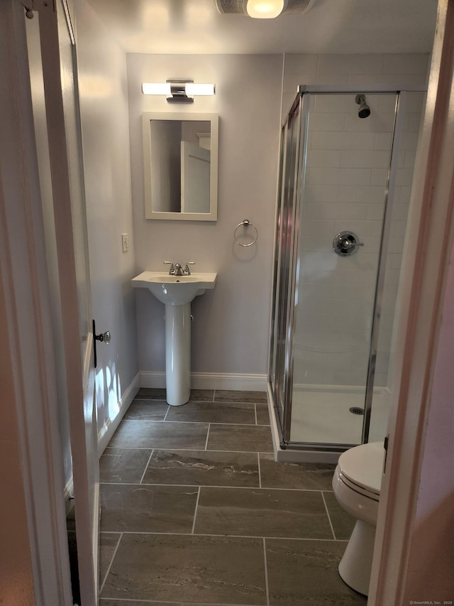 full bath with a shower stall, toilet, and baseboards