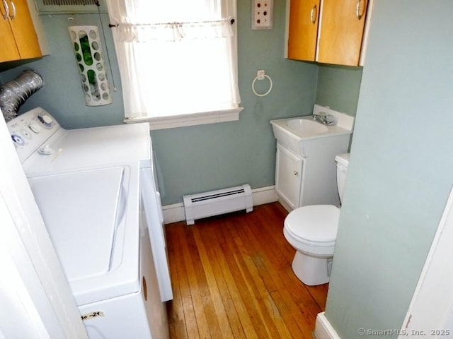 washroom with hardwood / wood-style floors, baseboards, laundry area, a sink, and a baseboard heating unit