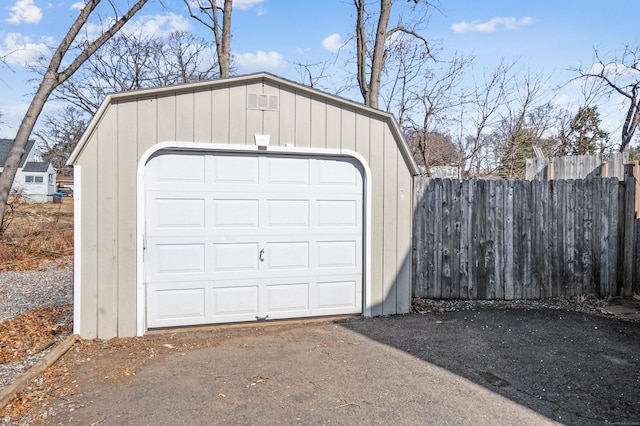 detached garage featuring fence