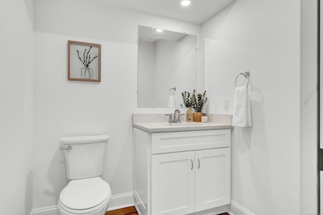 bathroom featuring recessed lighting, baseboards, toilet, and vanity